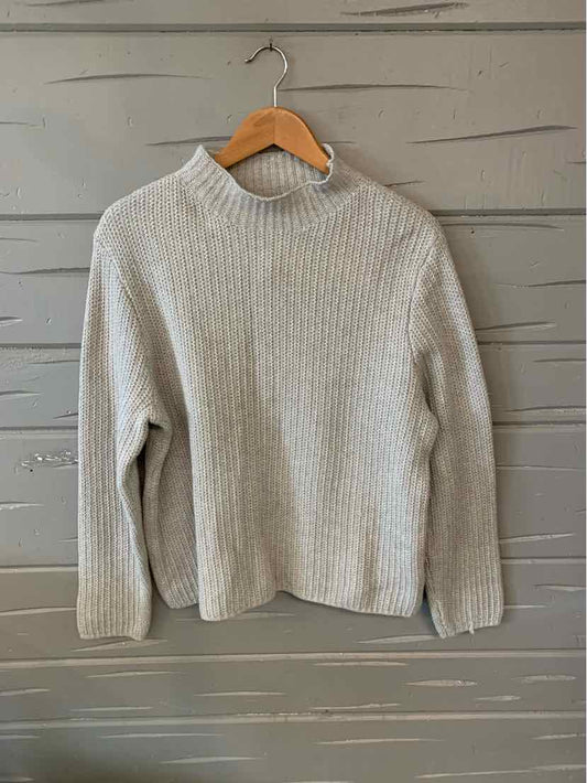 Light gray ribbed knit sweater with long sleeves and a relaxed fit on wooden hanger.