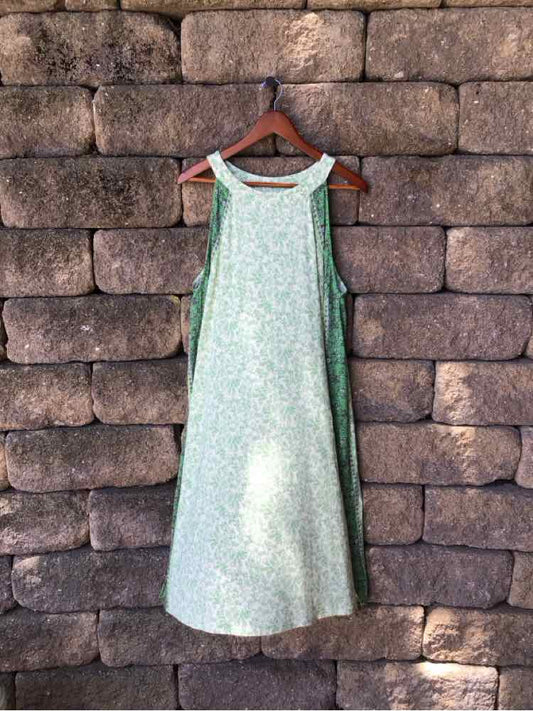 Light green sleeveless midi dress with a subtle floral pattern and a round neckline.