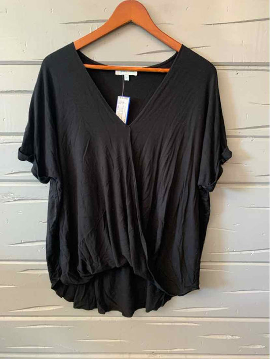 Black loose-fit women's casual top with short sleeves and a V-neck on a wooden hanger.