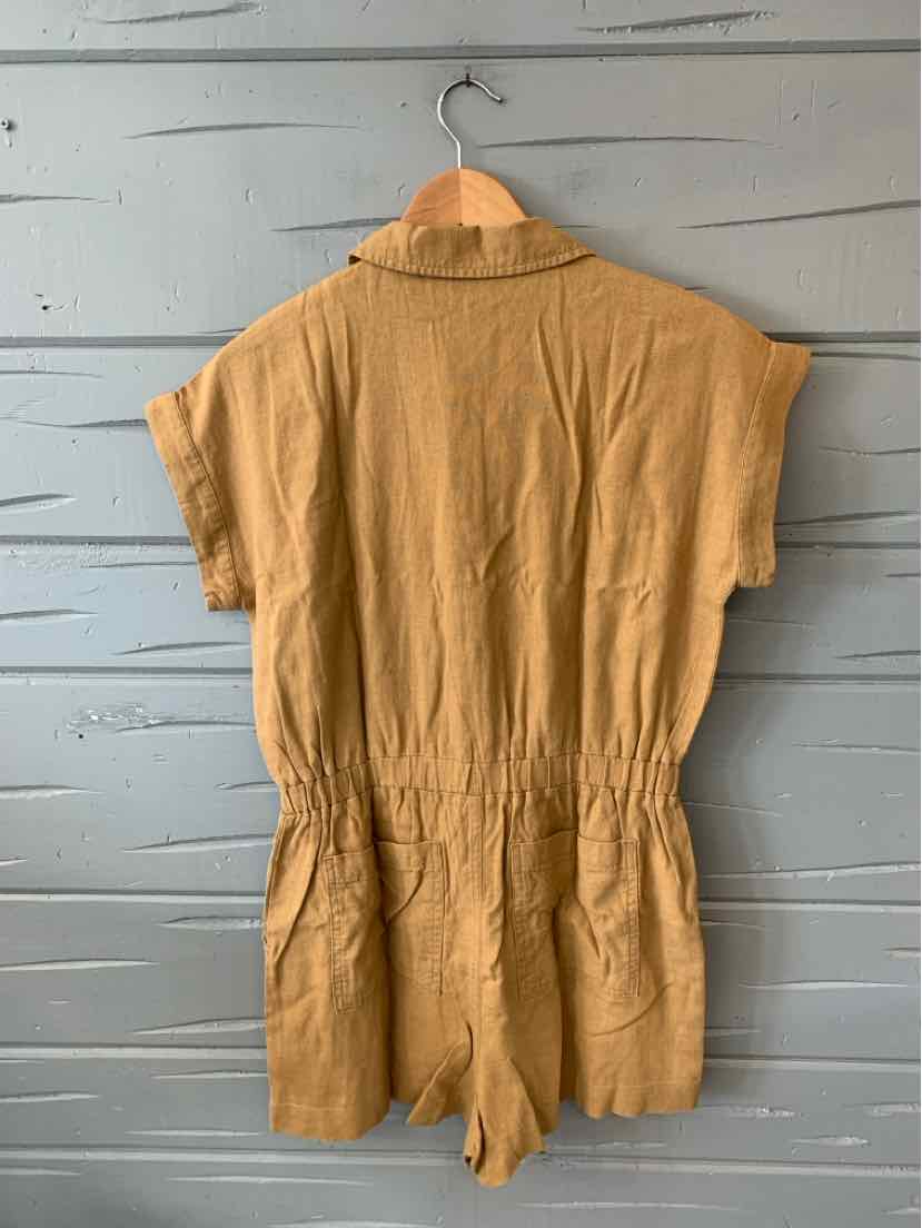 Tan short-sleeve romper with a collared neckline and cinched waist hanging on wooden hanger.