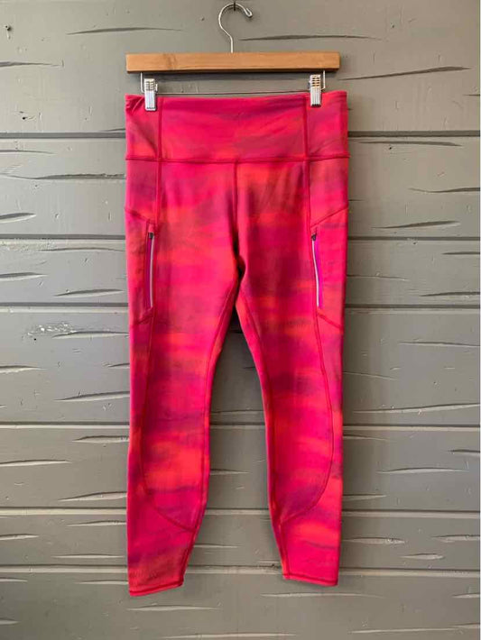 Pink and red patterned athletic leggings with high waistband and side pockets.