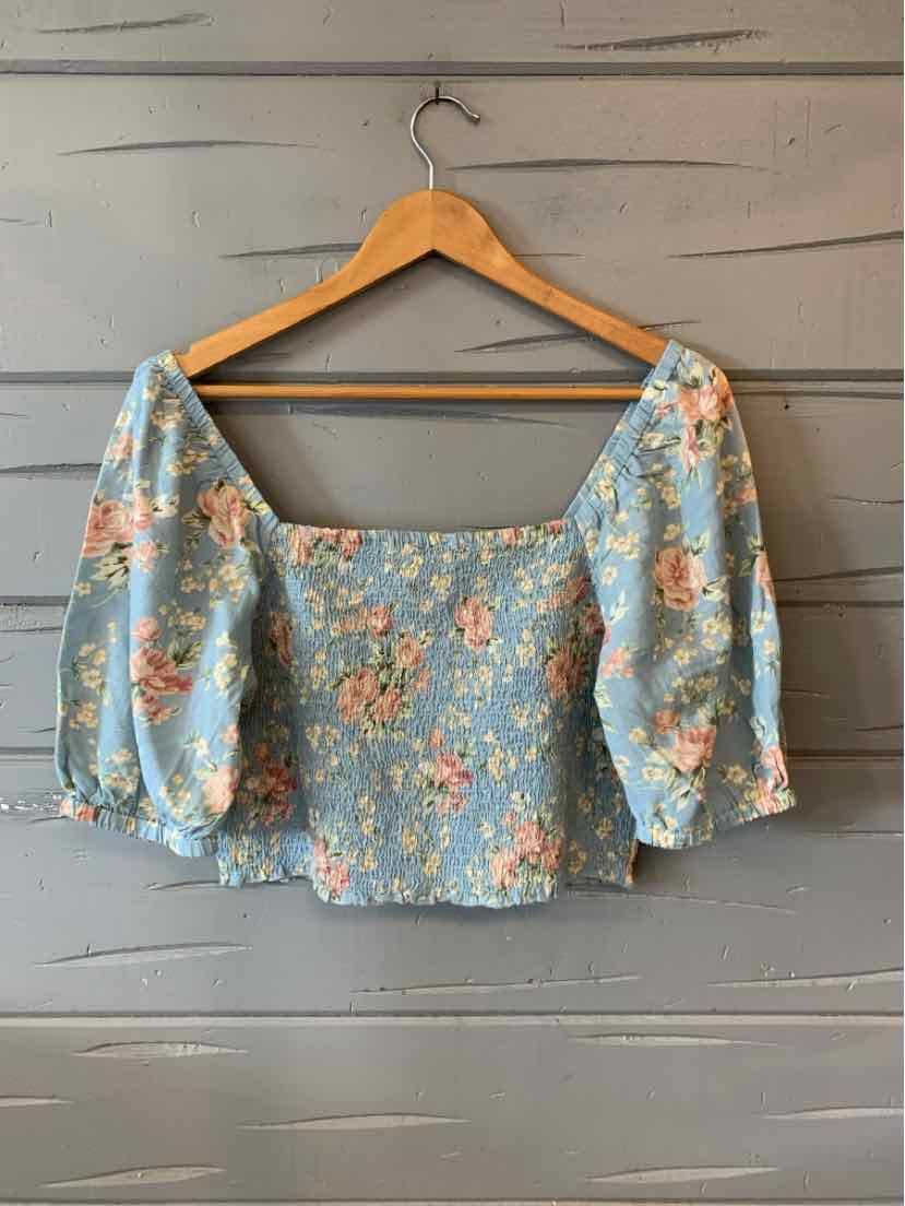 Light blue crop top with puffed elbow-length sleeves and peach floral print.
