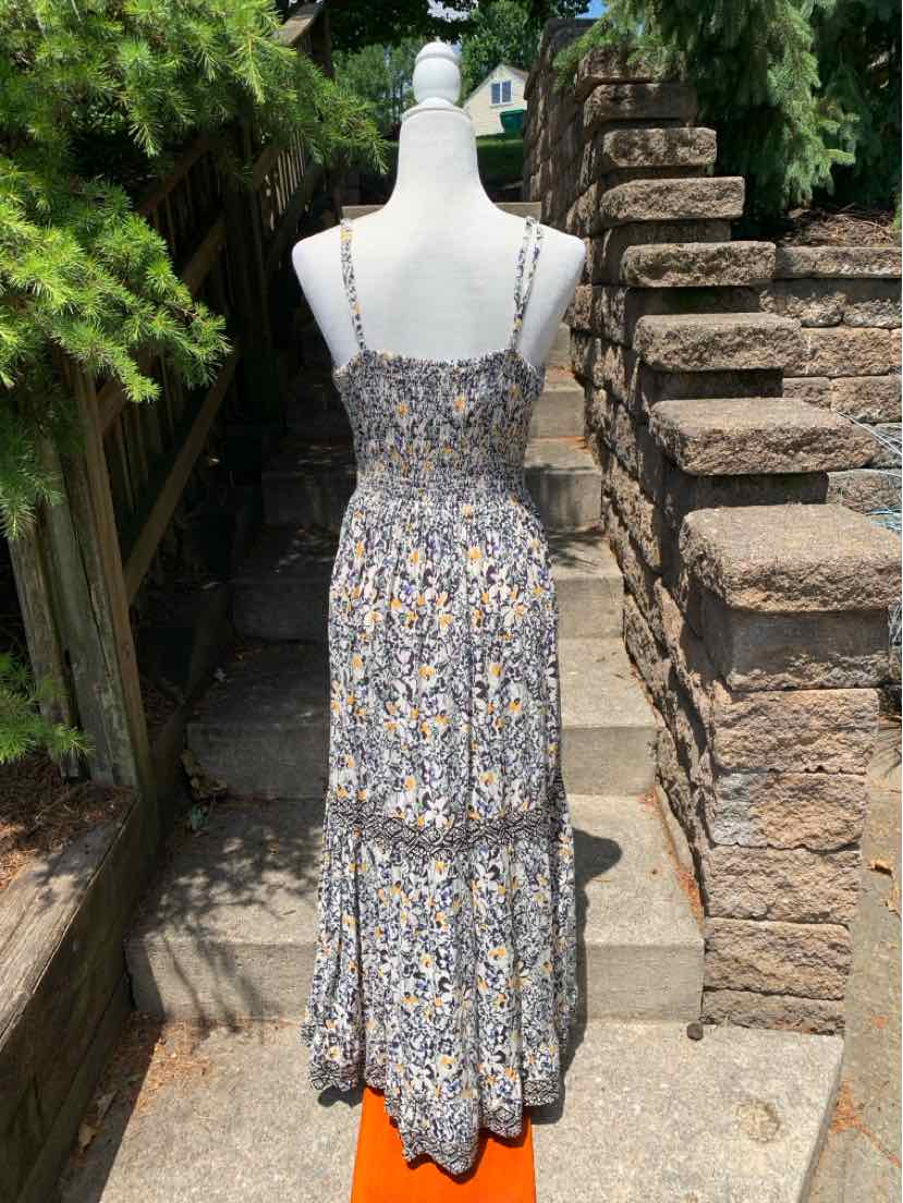 Floral sleeveless maxi dress with smocked back and adjustable thin straps in muted tones.
