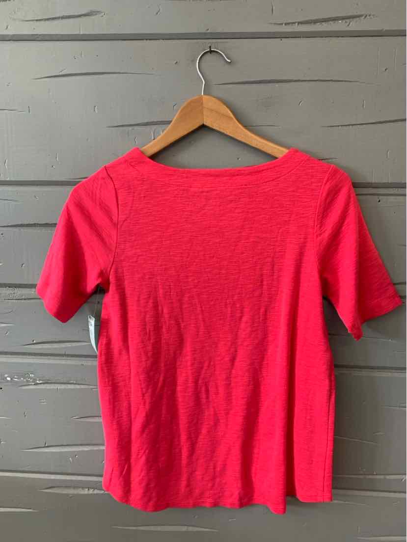 Bright pink short-sleeve lightweight knit top with crew neckline on wooden hanger.