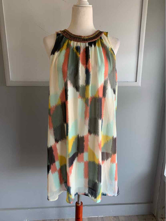 Sleeveless dress with loose fit and watercolor-inspired geometric pattern in white, yellow, orange, gray, and black.
