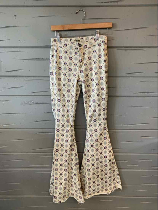 High-waisted flared pants with colorful geometric pattern on cream fabric.