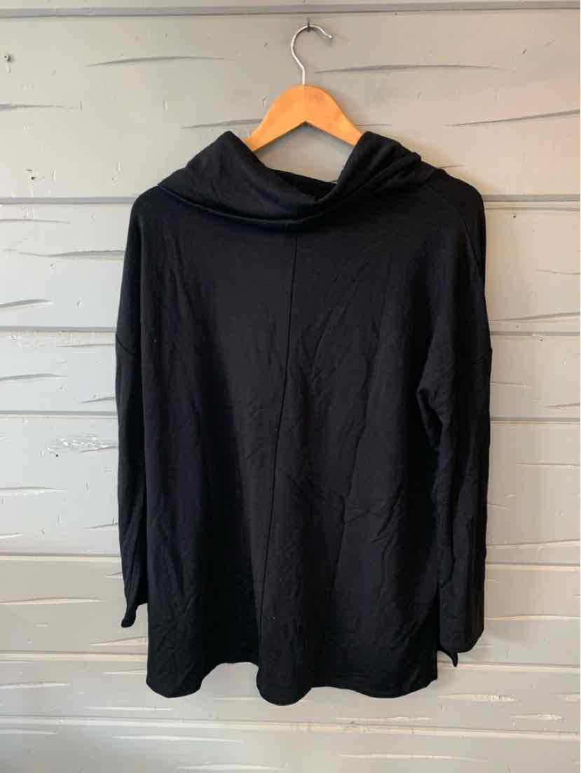 Black long-sleeve oversized hoodie with a loose fit, hanging on wooden hanger.