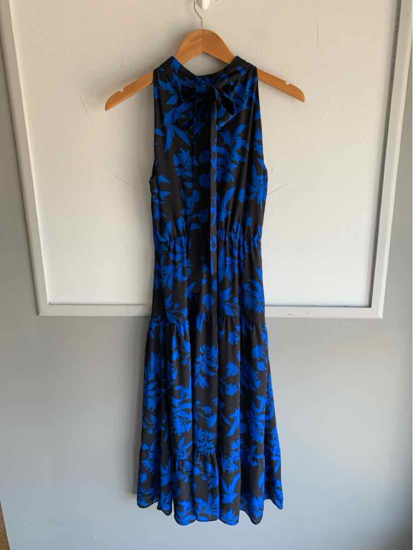 Black sleeveless midi dress with blue floral print and gathered waist on wooden hanger.