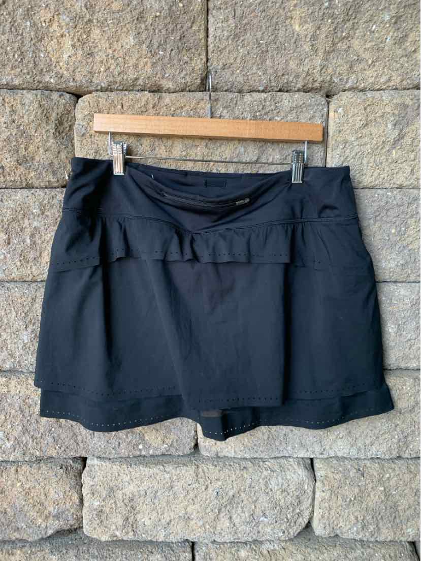 Black athletic skort with built-in shorts, lightweight fabric, and a wide waistband.