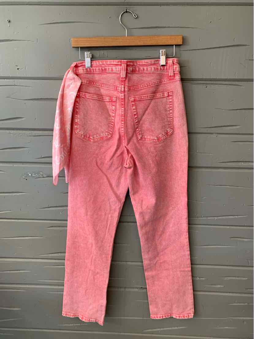 Pink denim jeans with a high waist, straight legs, and a matching fabric belt tied at the side.