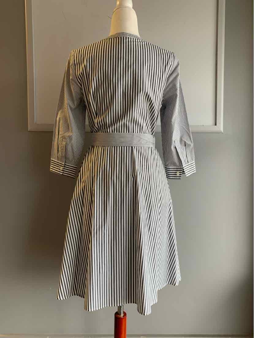 Gray and white vertical striped knee-length dress with three-quarter sleeves and a waist tie belt, back view.