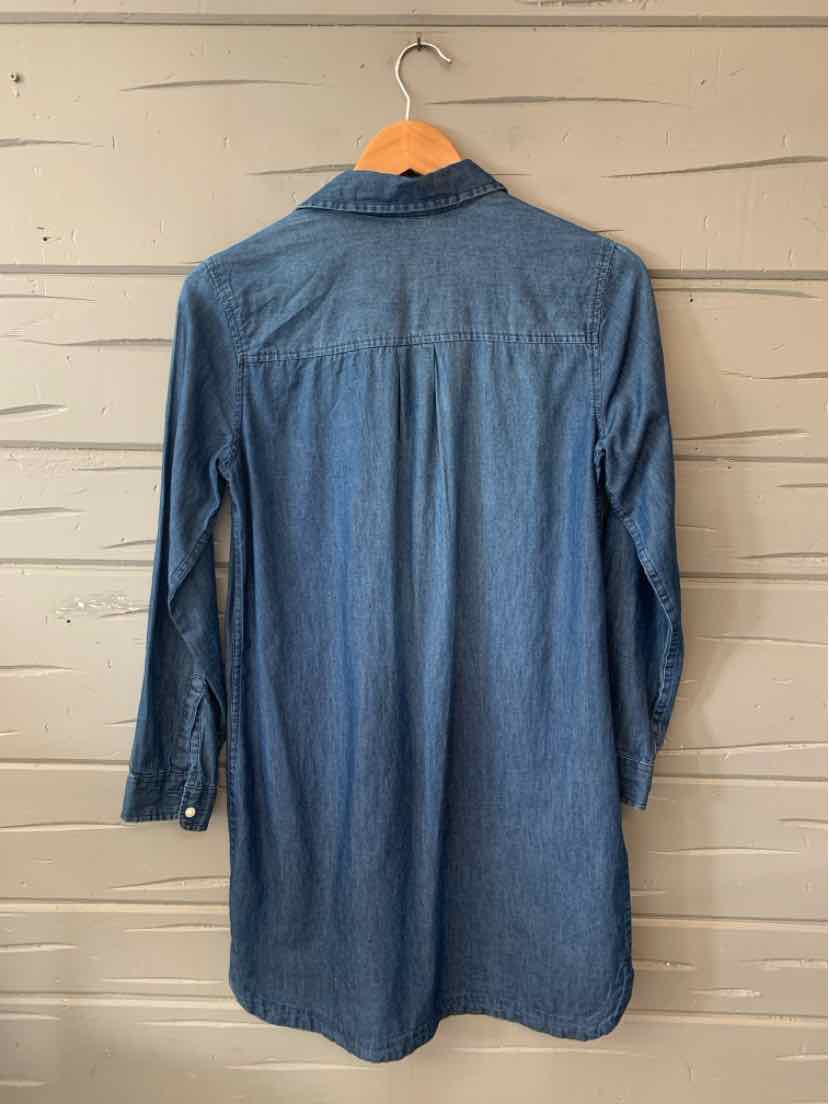Long-sleeve dark blue denim shirt dress with buttoned cuffs hanging on wooden hanger.