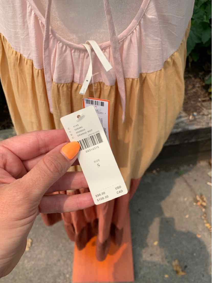 Color block dress in soft pink, peach, and rust tones with a drawstring waist and lightweight fabric.