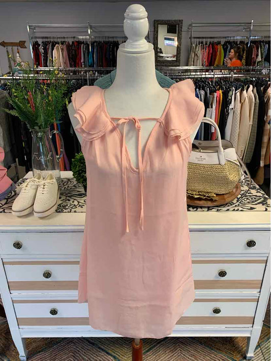 Light pink sleeveless dress with ruffled shoulders and front tie detail on mannequin.