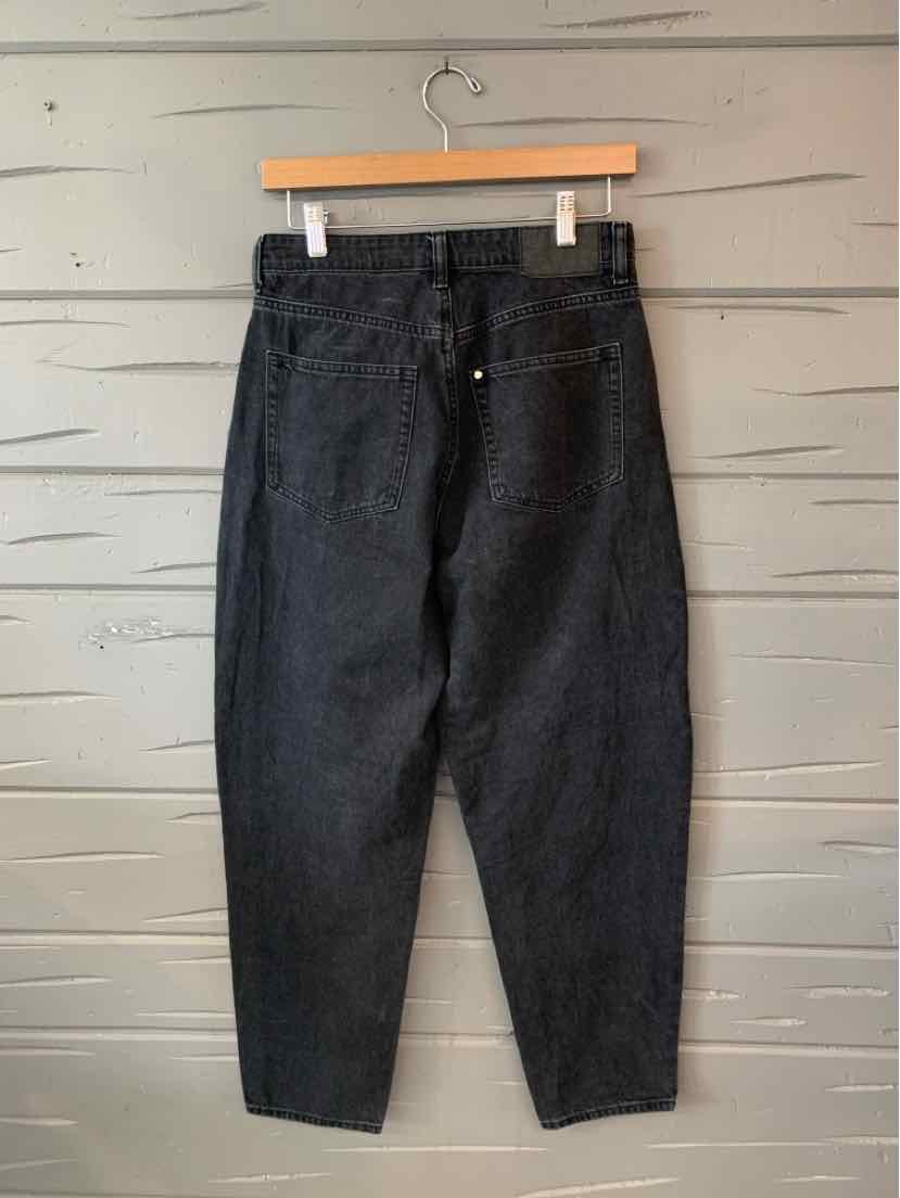 Black high-waist denim jeans with tapered legs and back pockets on wooden hanger.