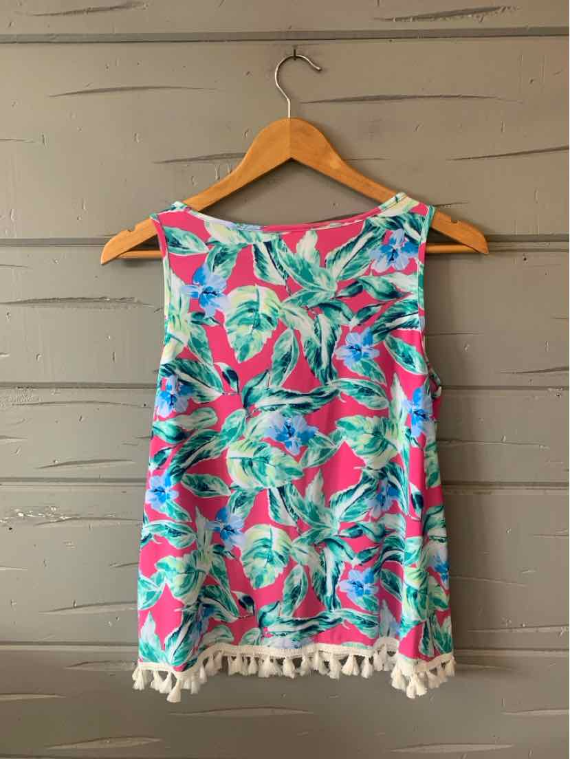 Pink tropical print sleeveless top with green and blue leaves, white tassel trim at hem, lightweight fabric.