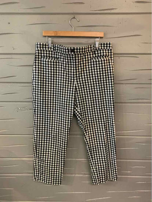 Black and white gingham checkered slim-fit pants size 16 with belt loops hanging on wooden hanger.