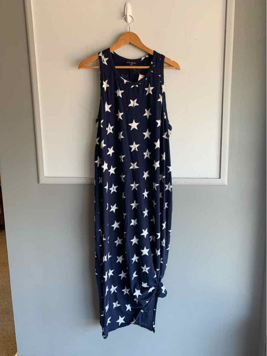 Navy blue sleeveless maxi dress with white star print and relaxed fit hanging on wood hanger.