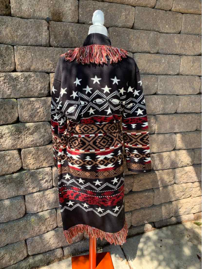 Black Southwestern patterned long coat with red and white geometric designs, fringe detailing on shoulders and hem.