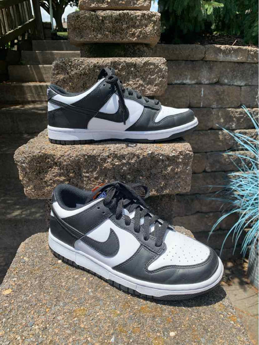 Low-top Nike sneakers in black, white, and gray with a leather upper and lace closure, size 8.5.