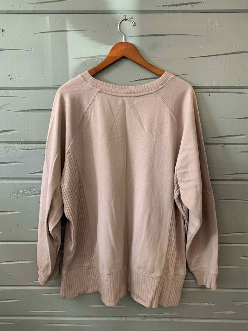 Taupe women's long-sleeve sweater with a crew neck and ribbed cuffs, hanging on a wooden hanger.