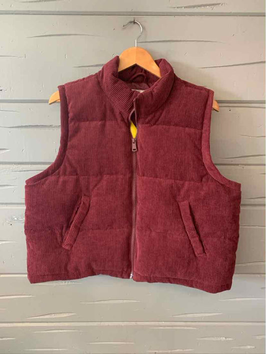 Sleeveless burgundy fleece vest with front pockets and a yellow zipper pull on wooden hanger.