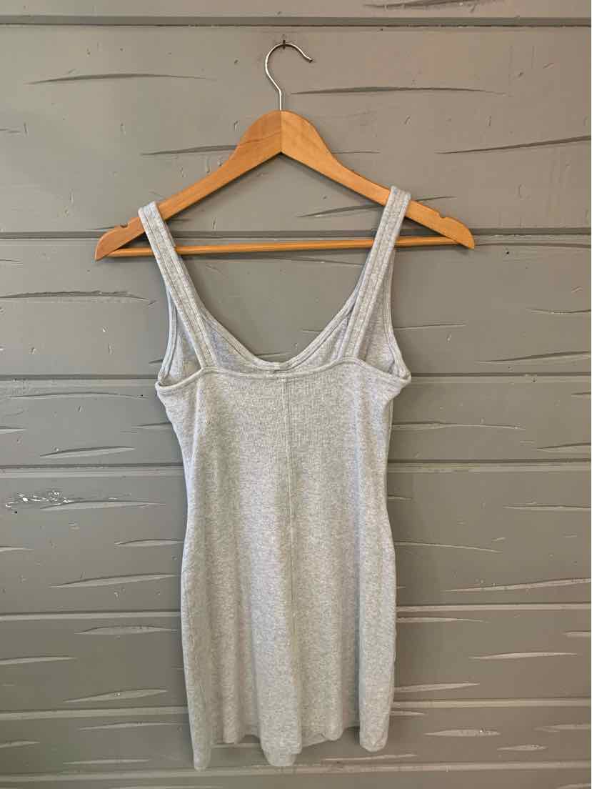 Light gray sleeveless scoop neck knit dress with wide straps hanging on wooden hanger.