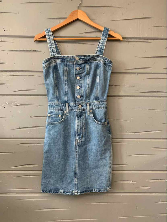 Blue denim button-front mini dress with adjustable straps and front pockets.
