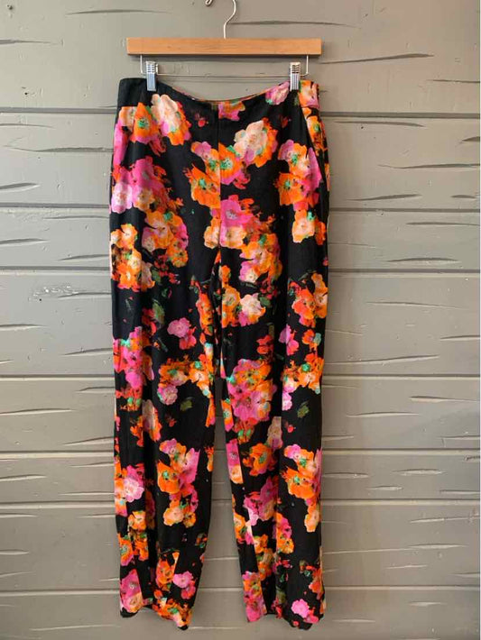 Black high-waist pants with vibrant orange, pink, and white floral pattern, slim fit.