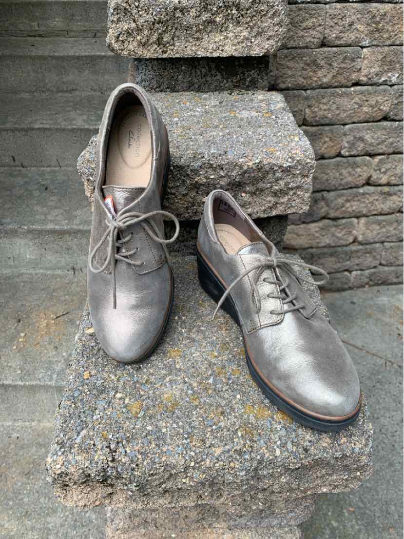 Women's size 10 metallic silver leather lace-up shoes with low wooden heels.