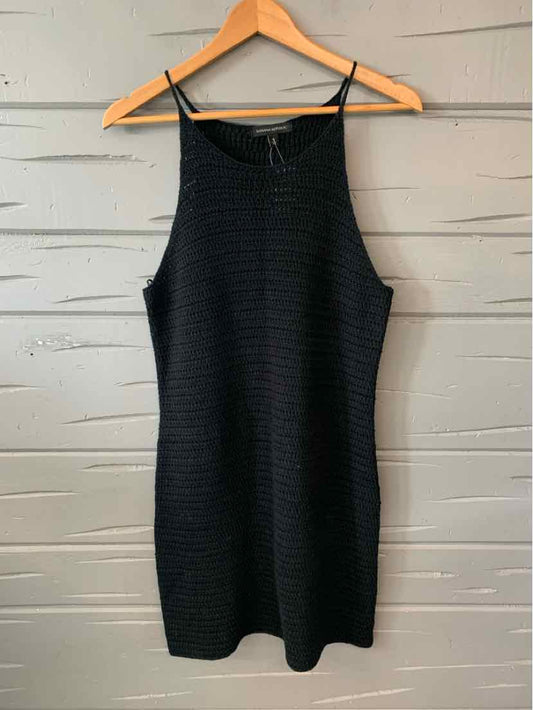 Black sleeveless ribbed knit dress with high neckline, medium size hanging on wooden hanger.