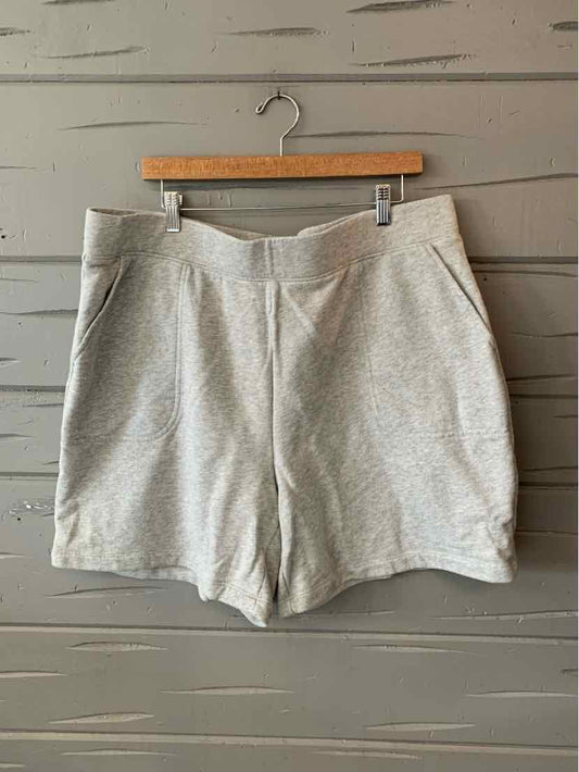 Light gray high-waisted shorts with side pockets and subtle texture on wooden hanger.