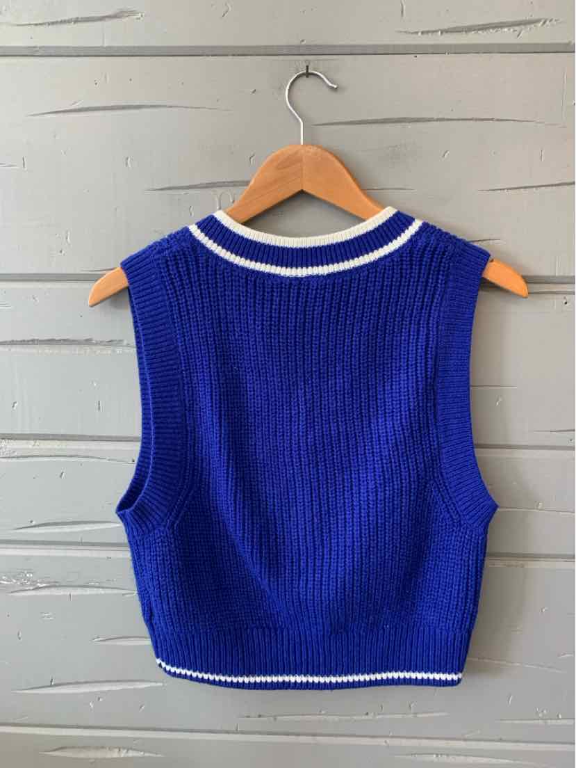 Royal blue sleeveless knit vest with white trim on the collar and hem, cropped fit.