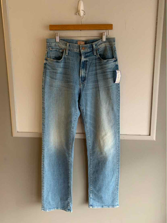 Light blue high-waisted denim jeans with straight legs and front button fly hanging on wooden hanger.