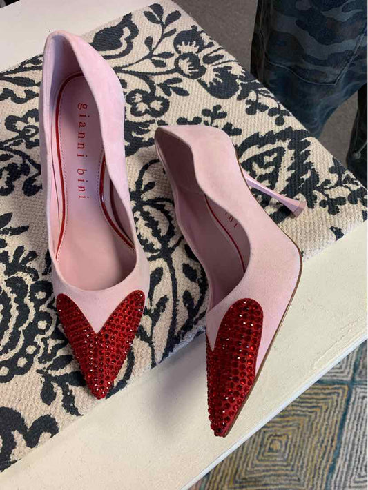 Pink pointed-toe pumps with red rhinestone heart embellishments on the toes.