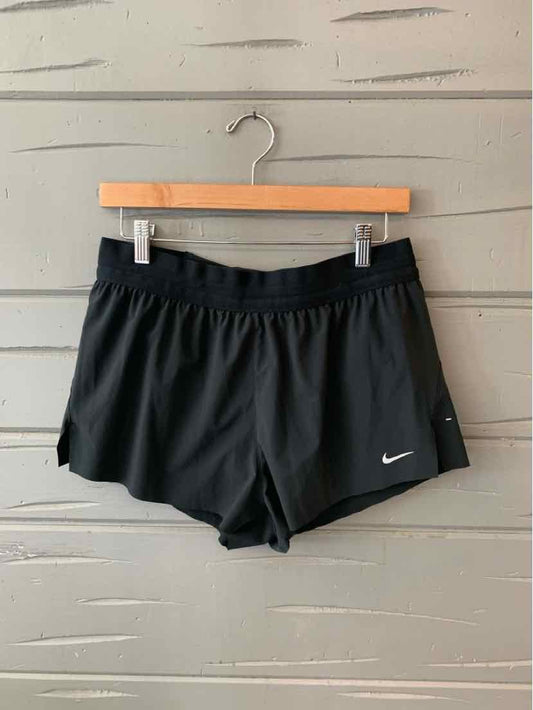 Black Nike women's athletic shorts with elastic waistband and small white swoosh logo on left hem.