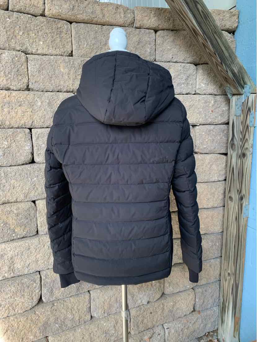 Black Michael Kors women’s puffer jacket with a hood, horizontal quilting, and long sleeves, shown from the back.