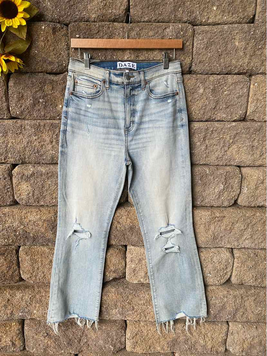 Light blue distressed denim jeans with ripped knees and frayed hems, cropped length.