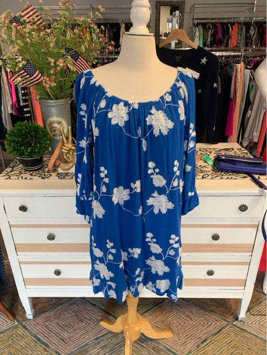 Blue loose-fit dress with white floral print and wide scoop neckline on mannequin.