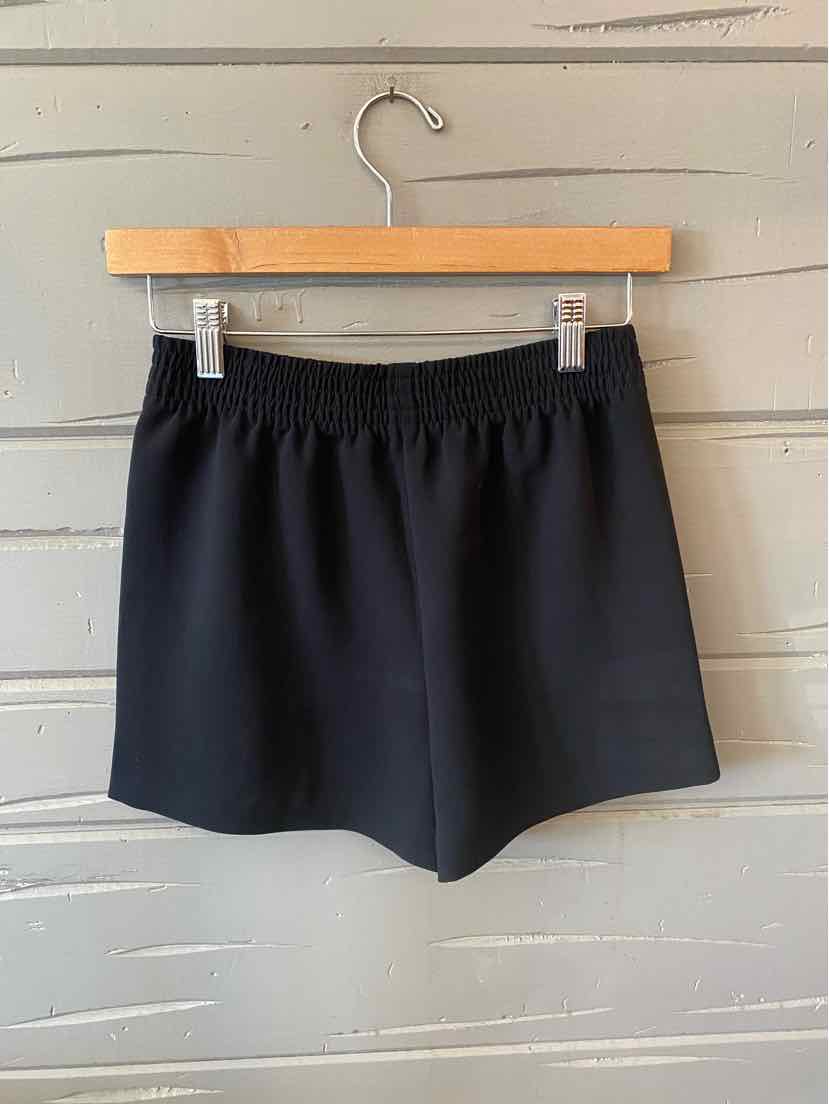 Black elastic waist shorts with a smooth, solid fabric and a relaxed fit in size XS.