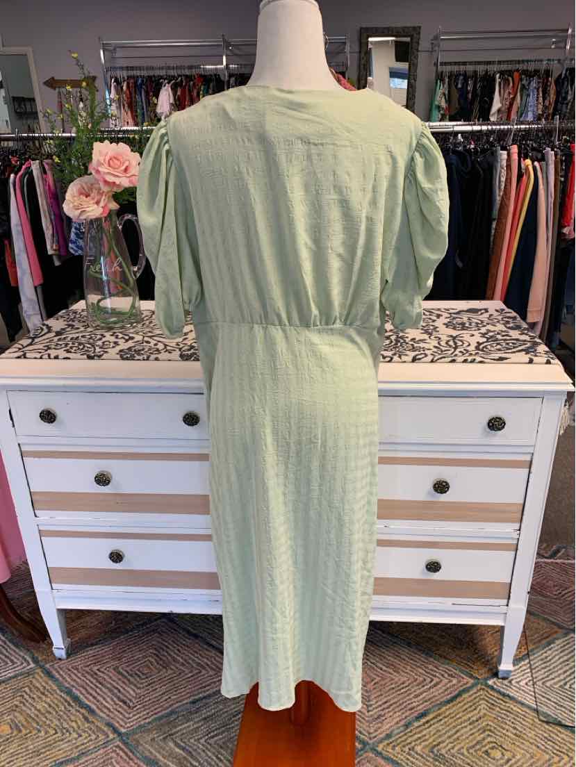 Light green midi dress with puff sleeves and gathered waist detailing on mannequin.