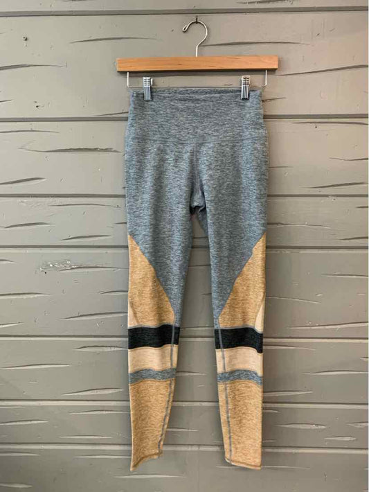 High-waisted leggings with grey upper, tan lower sections, and black horizontal stripes above the ankles.
