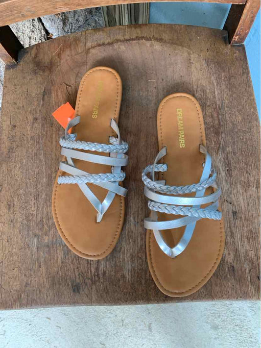 Light brown flat sandals with multiple thin silver braided straps and tan footbeds, open toe design.