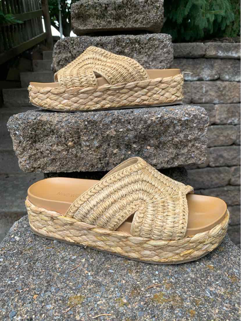 Tan woven platform sandals with thick crisscross straps and braided jute sole.