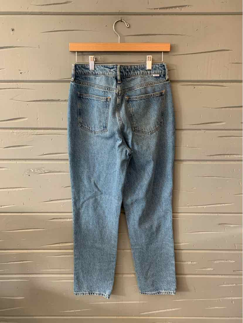 Blue denim jeans with a high waist, straight legs, and raw hem detailing hanging on a wooden hanger.
