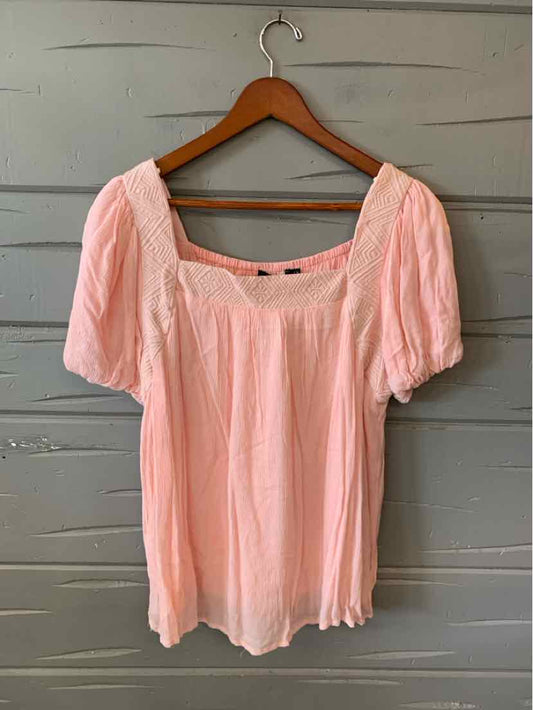 Light pink short-sleeve blouse with square neckline and gathered details on lightweight fabric.
