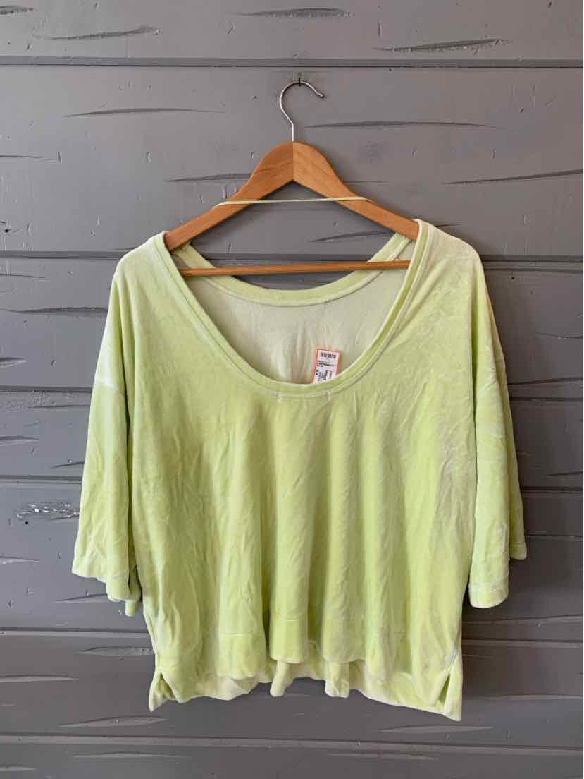 Light green loose-fit scoop neck T-shirt with short wide sleeves on wooden hanger.