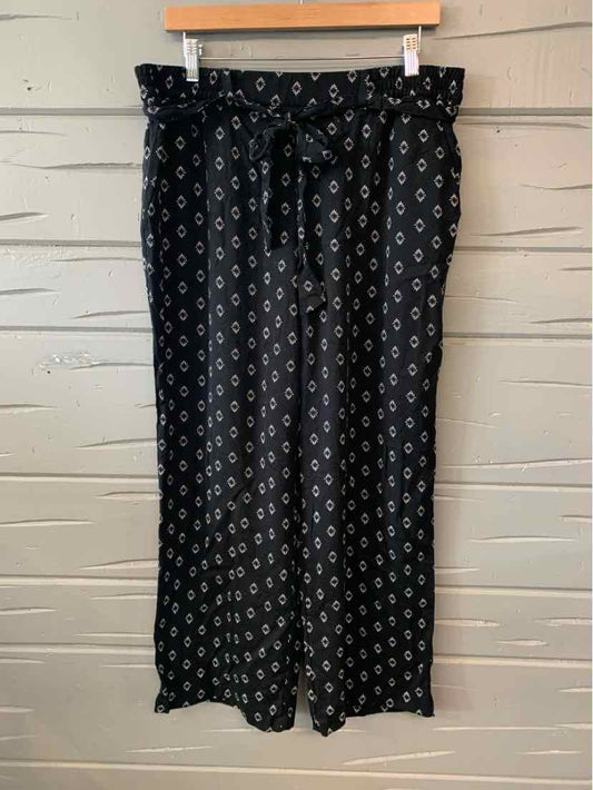 Black wide-leg pants with white geometric pattern and elastic paperbag waist with tie belt.