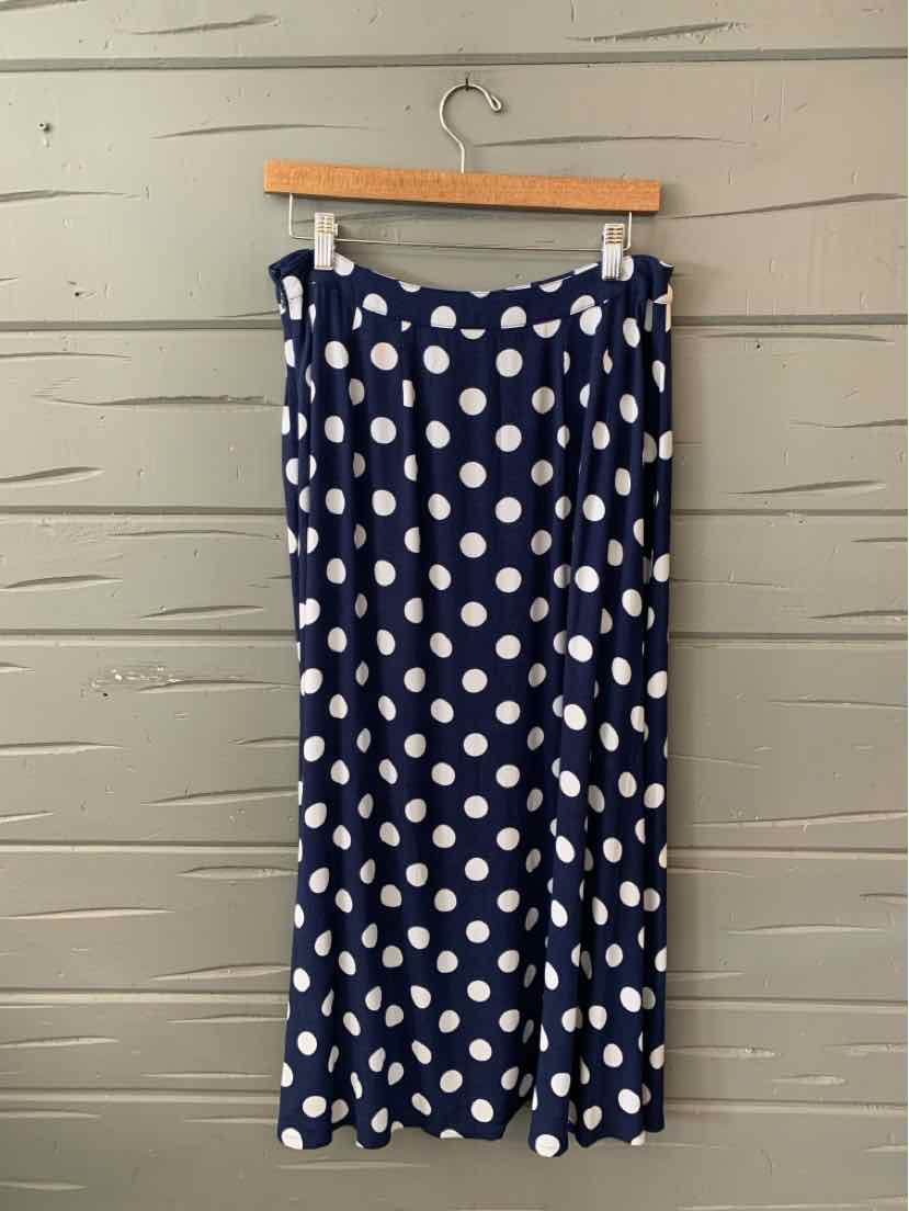 Navy blue skirt with large white polka dots, lightweight fabric, knee-length, relaxed fit.