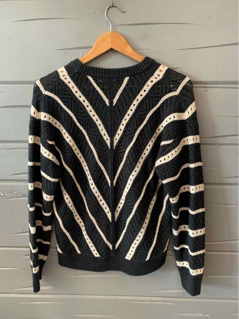 Gray knit sweater with white chevron and stripe patterns, long sleeves, and crew neckline.